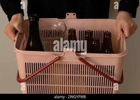 petite fille recyclant à la maison, bouteilles et bocaux en verre Banque D'Images