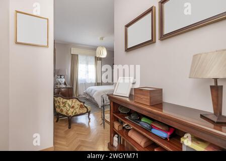 Antichambre d'une chambre avec une couette blanche et un lit double en bois à côté de la fenêtre Banque D'Images