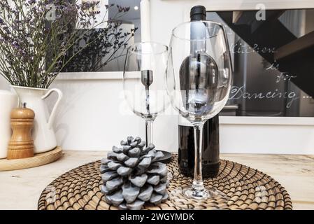 Une bouteille de vin rouge avec une paire de verres en cristal sur un tapis de fibres naturelles Banque D'Images