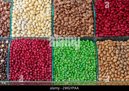 Piles de noix enrobées colorées et fruits secs vendus sur le marché en Turquie Banque D'Images