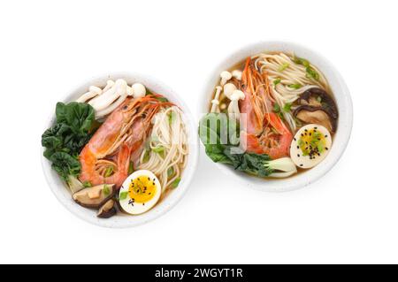 Délicieux ramen avec des crevettes et des œufs dans des bols isolés sur blanc, vue de dessus. Soupe de nouilles Banque D'Images