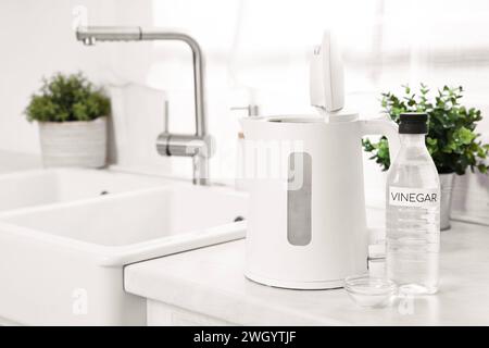 Nettoyage de la bouilloire électrique. Bouteille de vinaigre et bicarbonate de soude sur le comptoir dans la cuisine Banque D'Images