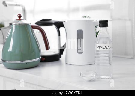 Nettoyage de la bouilloire électrique. Bouteille de vinaigre et bicarbonate de soude sur le comptoir dans la cuisine Banque D'Images