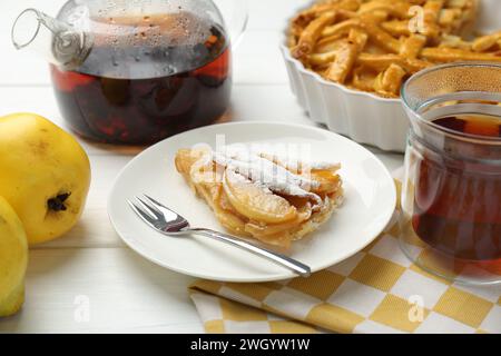 Morceau de savoureuse tarte au coing maison avec du sucre en poudre servi sur une table en bois blanc Banque D'Images