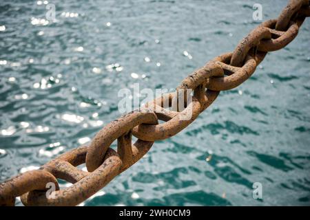 Ancre de chaîne de navire rouillé dans le fond abstrait d'eau de mer. Banque D'Images