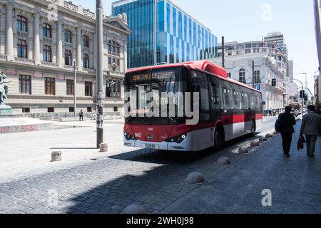 Les bus rouges du système Red de Santiago sont emblématiques, offrant des services de transport essentiels aux résidents et aux visiteurs. Banque D'Images