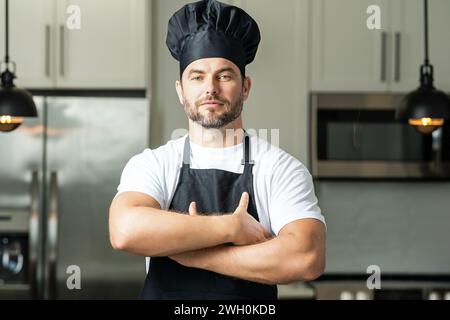 Portrait de chef dans un chapeau de chef dans la cuisine. Homme portant un tablier et uniforme de chef et chapeau de chef. Character kitchener, chef de la publicité Banque D'Images