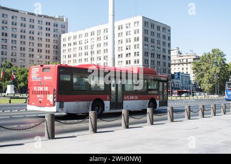 Les bus rouges du système Red de Santiago sont emblématiques, offrant des services de transport essentiels aux résidents et aux visiteurs. Banque D'Images