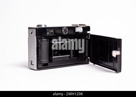 L'arrière d'un appareil photo rétro noir et argent est ouvert, exposant la chambre du film. La caméra est isolée sur un fond blanc, mettant en valeur le d classique Banque D'Images