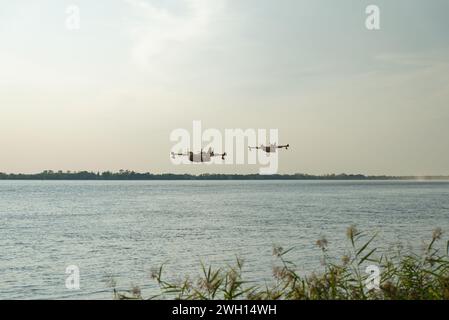 Canadairs du pompier en vol, se remplissant d'eau, sur la rivière Dordogne en Gironde Banque D'Images