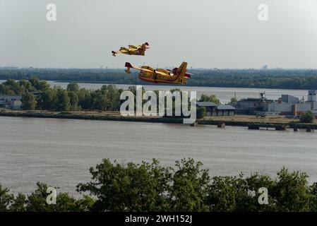 Canadairs du pompier en vol, se remplissant d'eau, sur la rivière Dordogne en Gironde Banque D'Images