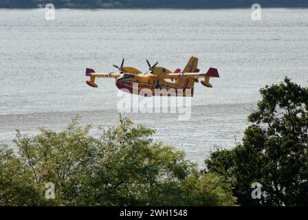 Canadairs du pompier en vol, se remplissant d'eau, sur la rivière Dordogne en Gironde Banque D'Images