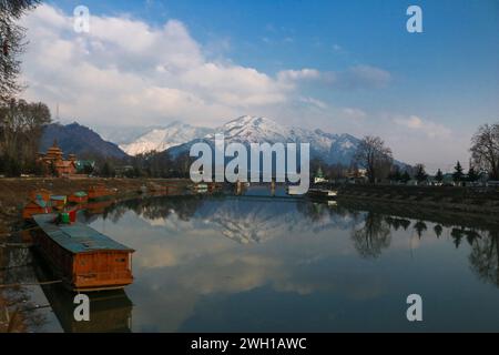 Non exclusif : février 05,2024, Srinagar Cachemire, Inde : Une vue de la rivière Jhelum et de la neige couverte des collines de Zabarwan pendant une journée ensoleillée après la neige fraîche Banque D'Images