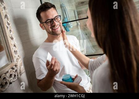 Couple passant par la routine matinale dans la salle de bain. Banque D'Images