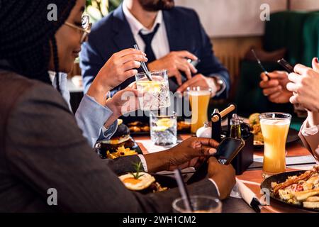 Mains de gens d'affaires assis dans un restaurant lors d'un déjeuner d'affaires. Banque D'Images