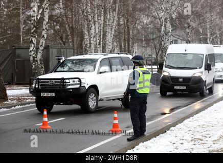 RÉGION DE KIEV, UKRAINE - 6 FÉVRIER 2024 - un policier armé monte la garde près d'une bande de pointes à l'un des emplacements de l'Académie nationale des affaires intérieures, région de Kiev, dans le nord de l'Ukraine. Banque D'Images