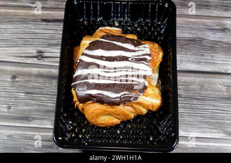 Pâtisserie danoise cuite farcie et garnie de chocolat noir brun et sauce au chocolat blanc, pâte à pâtisserie sucrée cuite au four avec de la farine, du sucre et Banque D'Images