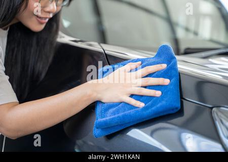 Femmes frottant la voiture avec un chiffon d'essuyage. Banque D'Images