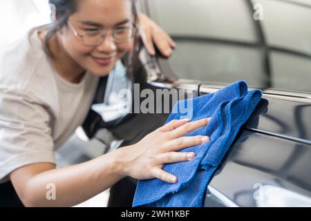 Femmes frottant la voiture avec un chiffon d'essuyage. Banque D'Images