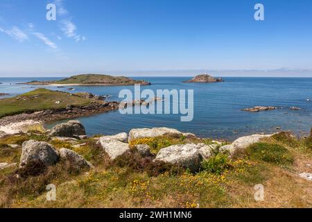 Round Island avec son phare, et composé Helen's, de l'île inhabitée voisine de Teän, îles Scilly, Royaume-Uni Banque D'Images