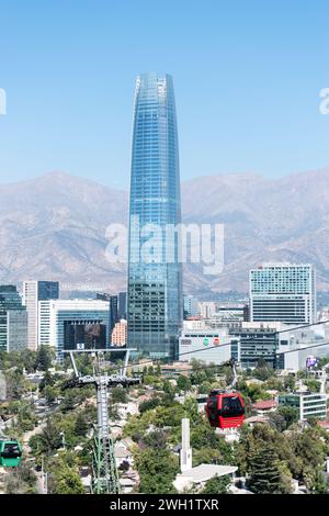 Paysage urbain depuis le parc métropolitain de Santiago en été, avec l'emblématique tour Costanera et le téléphérique au loin. Banque D'Images