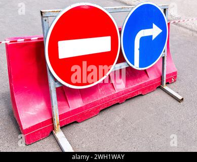 Panneaux routiers : pas de passage, direction de la circulation sur une rue de la ville en été. Chaussée fermée. Bloquer la circulation pour le transport Banque D'Images
