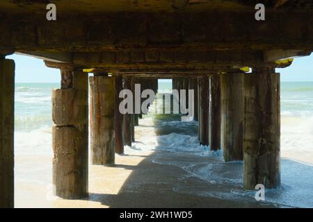 Vagues sous la jetée sur la plage de la côte atlantique, ralenti, Villa Gesell, Argentine, 02.01.2024 Banque D'Images