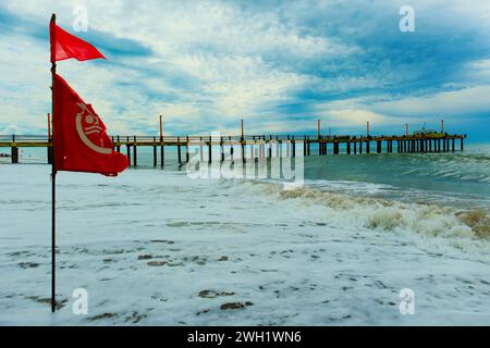 Drapeau avec interdiction de baignade se développe dans le vent, plage de la côte Atlantique, Villa Gesell, Argentine, 02.01.2024 Banque D'Images