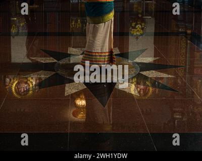 Une femme indienne portant des vêtements traditionnels marchant sur un sol en forme d'étoile. Banque D'Images