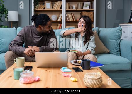 Jeune couple intelligent propriétaires d'entreprise et partenaires architectes d'intérieur extérieur concepteurs travaillant de la maison sur ordinateur portable avec Blueprint et colo Banque D'Images