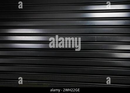 Partie de la porte métallique fermée. Noir et blanc, monochrome. ECLAIRAGE de forme abstraite par néon. Banque D'Images