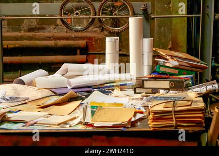 Image d'une grande table dans un atelier jonchée de vieux dessins et dossiers Banque D'Images