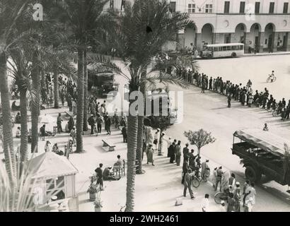 La deuxième migration des colons ruraux italiens en Libye : colonnes de camions transportant les ruraux vers les fermes de Gebel Cyrenaico dans les rues de Tripoli, Libye 1938 Banque D'Images