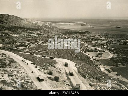 La deuxième migration des colons ruraux italiens en Libye : le port de Ras Hilal avec les navires des colons et les colonnes de camions transportant les populations rurales aux fermes de Gebel Cyrenaico, Libye 1938 Banque D'Images