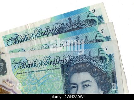Notes de cinq livres représentant un portrait de la reine Elizabeth II du Royaume-Uni isolées sur fond blanc. Banque D'Images