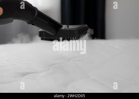 Nettoyage et désinfection du matelas dans la chambre à coucher avec de la vapeur chaude Banque D'Images