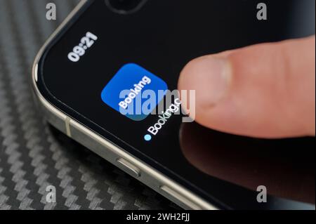 New York, États-Unis - 24 janvier 2024 : toucher l'icône supérieure de l'application de réservation ouverte avec le doigt sur iphone 15 pro max gros plan Banque D'Images