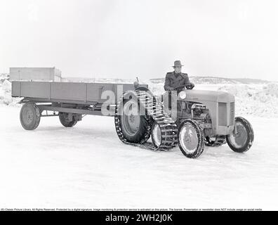 Tracteur Ferguson dans les années 1950 Un conducteur sur le légendaire tracteur Ferguson présenté avec des bracelets caterpillar et un wagon à un essieu derrière. Les tracteurs Ferguson ont été les premiers tracteurs agricoles modernes et leur système d'attelage à trois points a constitué un développement majeur. 1951. Kristoffersson ref BB46-4 Banque D'Images