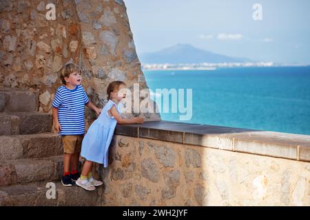 Les petits touristes apprécient une vue imprenable sur la mer depuis les murs de Peniscola Banque D'Images