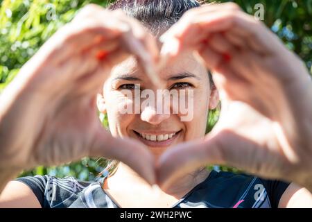 Femme latine faisant un cœur avec ses mains Banque D'Images