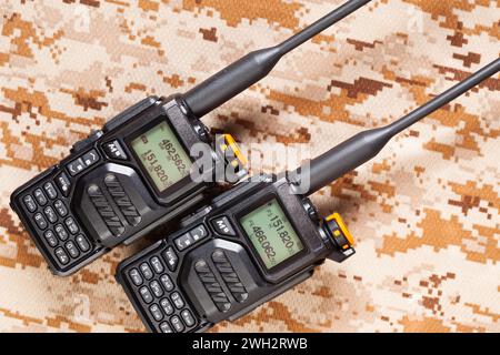 Paire de radios bidirectionnelles UHF VHF sur fond de camouflage vert Banque D'Images