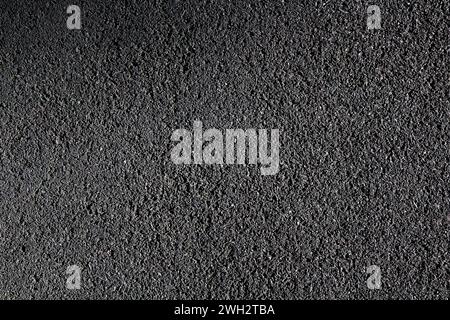 Texture de la housse en caoutchouc pour les pistes de course et les terrains de jeux. Fond d'asphalte caoutchouté noir. Banque D'Images