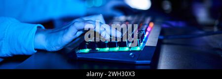 bannière de mains féminines recadrées tapant sur le clavier d'ordinateur avec éclairage, lumière bleue Banque D'Images