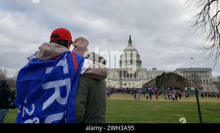 Washington, DC, États-Unis. 06 janvier 2021. Un couple regarde des partisans du président américain Donald Trump briser le Capitole. Banque D'Images