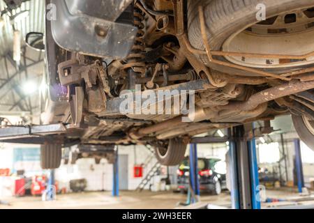 Eléments et conception de la suspension arrière d'une voiture. Bras de suspension, ressorts, amortisseurs. La voiture est levée sur un ascenseur. Diagnostic et entretien o Banque D'Images