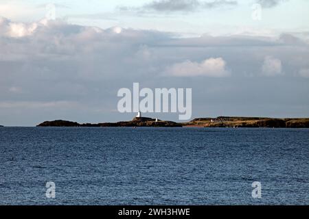 Vue sur le détroit de Menai jusqu'à Traeth Llanddwyn et Goleudy Tŵr Mawr sur Ynys Llanddwyn, Llanddwyn Island, Anglesey, Nord du pays de Galles. Banque D'Images