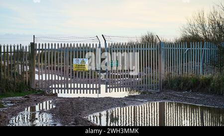 Portes de sécurité métalliques et flaques d'eau sur l'ancien site de l'usine chimique ici, Fleetwood, Royaume-Uni Banque D'Images