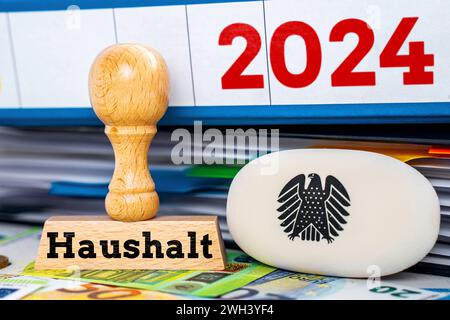 7 février 2024 : budget fédéral 2024, Un timbre à côté des dépliants et des billets en euros avec un logo de l'aigle fédéral allemand avec l'inscription : budget FOTOMONTAGE *** Bundeshaushalt 2024, Ein Stempel neben Ordnern und Euro Geldscheinen mit einem logo des deutschen Bundesadlers mit der Aufschrift : Haushalt FOTOMONTAGE Banque D'Images