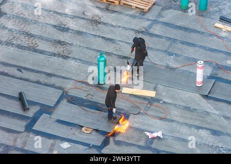 Ouvriers de la construction effectuant des travaux d'imperméabilisation sur un plafond de bâtiment avec des membranes de bitume Vienne 22. Donaustadt Wien Autriche Banque D'Images