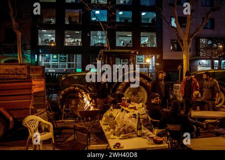 Barcelone, Espagne. 7 février 2024. Les agriculteurs ont un barbecue après les heures de travail pour protester contre la politique agricole européenne, la hausse des coûts, la diminution des revenus et la concurrence déloyale des pays tiers, rejoignant ainsi les protestations des pairs de l'UE. Crédit : Matthias Oesterle/Alamy Live News Banque D'Images